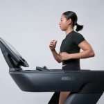 Donna che cammina sul tapis roulant: il trend del cozy cardio