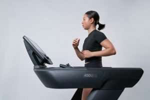 Donna che cammina sul tapis roulant: il trend del cozy cardio